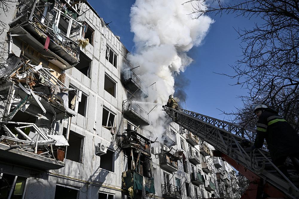 Los bomberos trabajan en un incendio en un edificio después de los bombardeos en la ciudad de Chuguiv, en el este de Ucrania, el 24 de febrero de 2022.