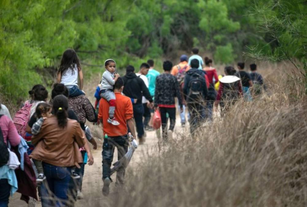 MISSION, TEXAS - MARCH 23: Asylum seekers, most from Honduras, walk towards a U.S. Border Patrol checkpoint after crossing the Rio Grande from Mexico on March 23, 2021 near Mission, Texas. A surge of migrant families and unaccompanied minors is overwhelming border detention facilities in south Texas' Rio Grande Valley. John Moore/Getty Images/AFP<br/><br/>== FOR NEWSPAPERS, INTERNET, TELCOS & TELEVISION USE ONLY ==<br/><br/>