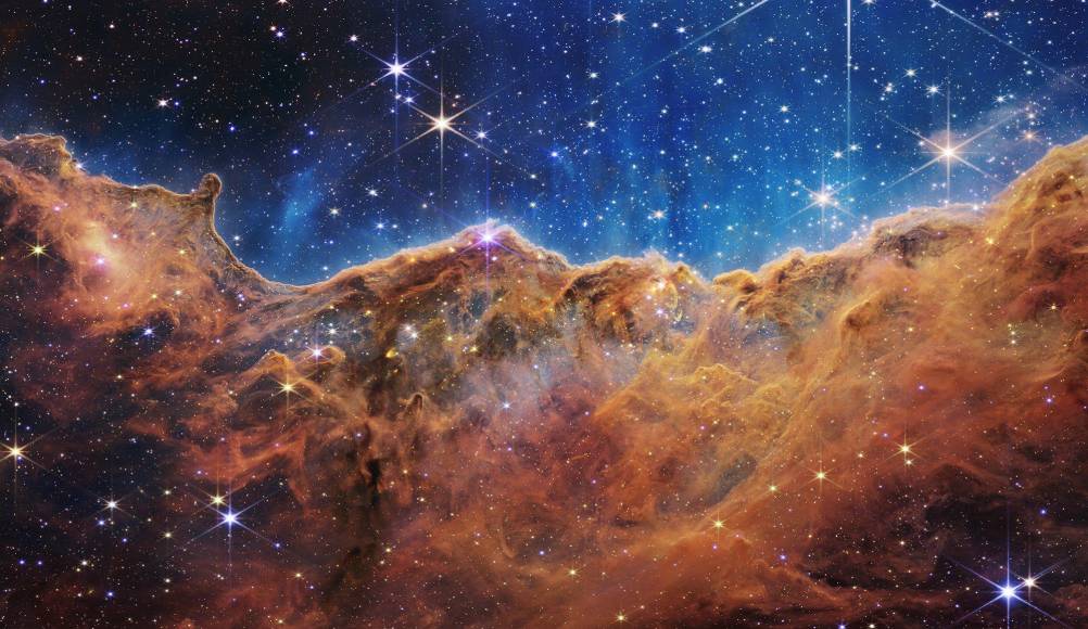 Denominados los precipicios cósmicos, la imagen aparentemente tridimensional del Webb luce como montañas escarpadas en una noche iluminada por la Luna.