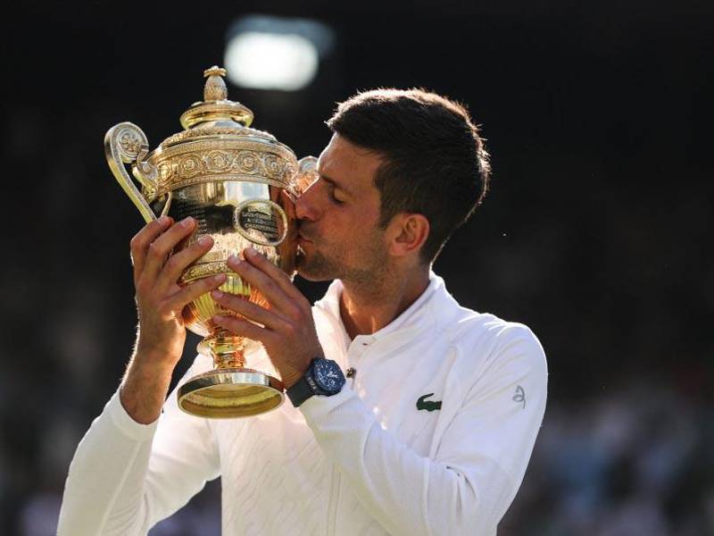 Novak Djokovic besando el título que lo acredita nuevamente como el rey de Wimbledon.