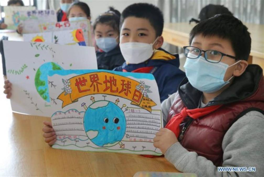 Los estudiantes exhiben sus pinturas durante una actividad que pide la protección de la Tierra y el medio ambiente en una escuela en la ciudad de Lianyungang, provincia de Jiangsu, este de China.