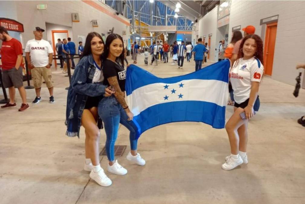 Ellas muy sonrientes luciendo la bandera de Honduras. Una con la camisa del Olimpia.