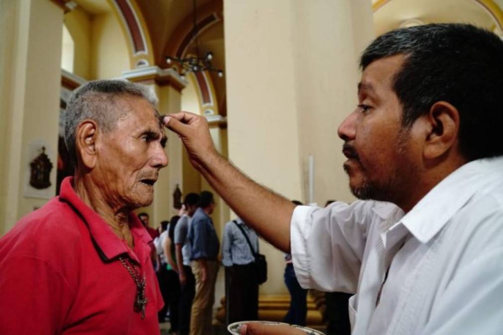 Un feligrés recibe su marca en la frente.