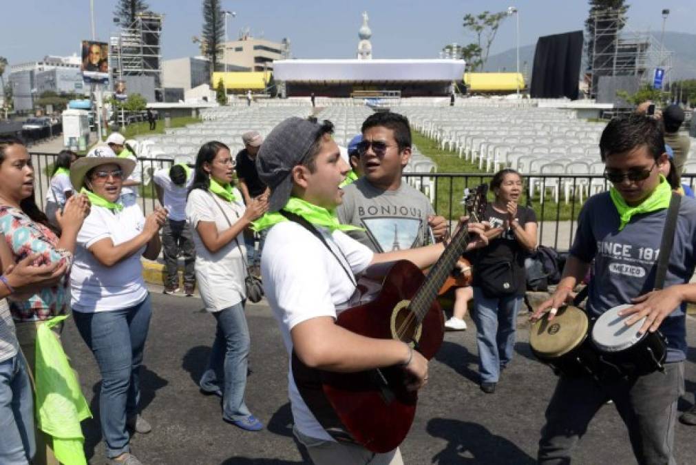 Una decena de jóvenes armados de guitarras y tambores danzaban y entonaban canciones religiosas, al tiempo que lanzaban gritos de 'viva Romero'.
