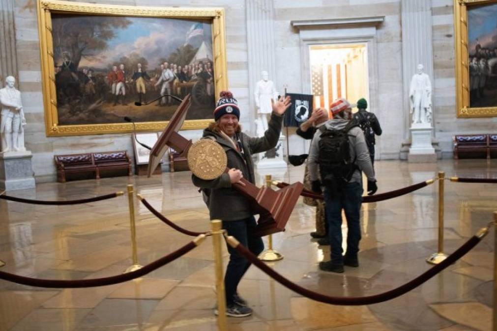 Adam Johnson, el del podio: Sorprendido por la cámara cuando se llevaba el podio de la presidenta de la Cámara de Representantes, Nancy Pelosi, este treintañero que llevaba una gorra de Trump hizo un gesto amistoso al fotógrafo, todo sonrisas.