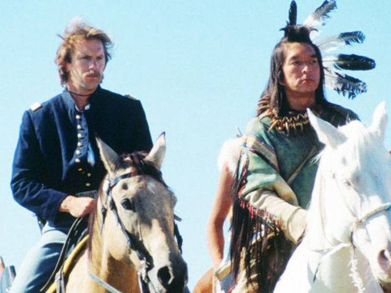Kevin Costner y Greene, miembro de la Nación Oneida, alcanzó la fama internacional con su papel del líder espiritual 'Ave que Patea' en 'Bailando con lobos' (1990), que le valió una nominación al Óscar como mejor actor de reparto.