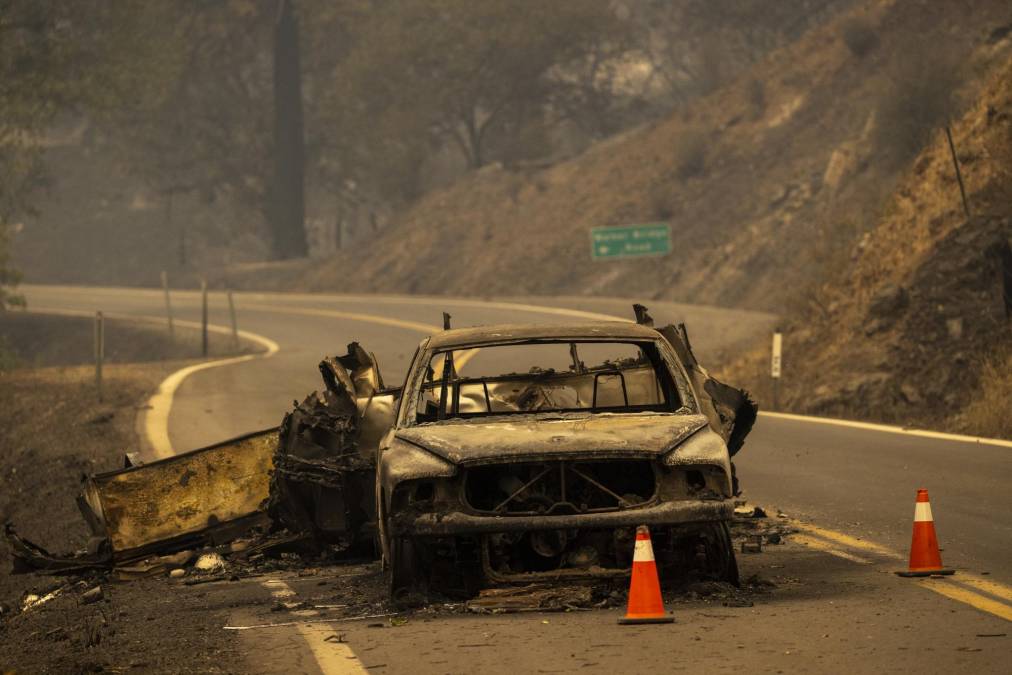 The charred remnants of a car towing a trailer that burned when fire jumped the Klamath River remain on the highway at the McKinney Fire in the Klamath National Forest northwest of Yreka, California, on July 31, 2022. - The largest fire in California this year is forcing thousands of people to evacuate as it destroys homes and rips through the state's dry terrain, whipped up by strong winds and lightning storms. The McKinney Fire was zero percent contained, CalFire said, spreading more than 51,000 acres near the city of Yreka. (Photo by DAVID MCNEW / AFP)