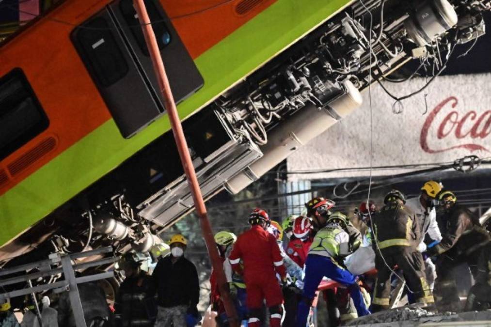 Rescue workers remove a body from a train carriage after an elevated metro line collapsed in Mexico City on May 4, 2021. (Photo by PEDRO PARDO / AFP)
