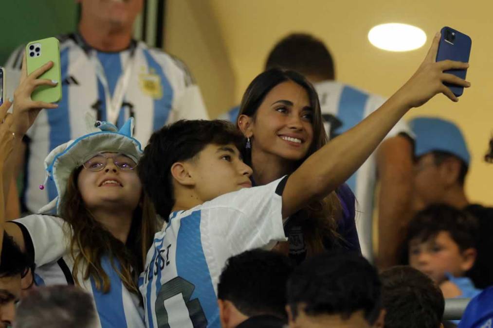 Antonela Roccuzzo posando con aficionados argentinos en el palco del Ahmad Bin Ali Stadium.