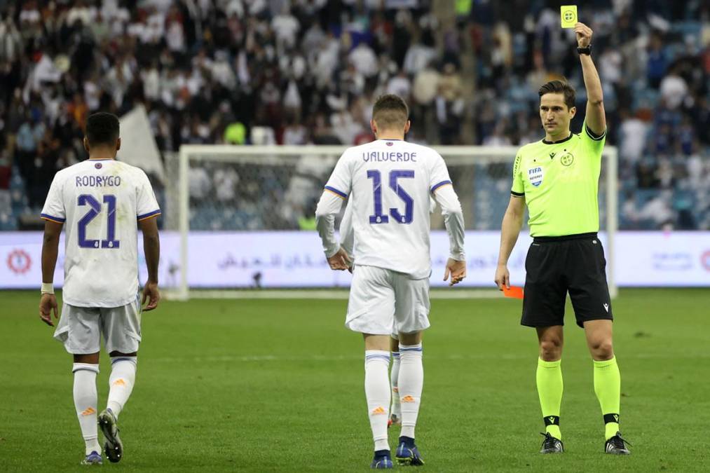 El árbitro José Luis Munuera Montero le muestra la tarjeta amarilla Fede Valverde por quitarse la camiseta en la celebración de su gol.
