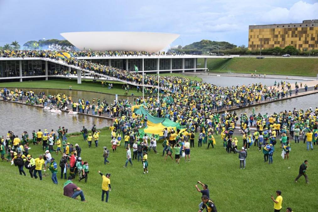 Supporters of Brazilian former President Jair Bolsonaro hold a demonstration at the Esplanada dos Ministerios in Brasilia on January 8, 2023. - Brazilian police used tear gas Sunday to repel hundreds of supporters of far-right ex-president Jair Bolsonaro after they stormed onto Congress grounds one week after President Luis Inacio Lula da Silva's inauguration, an AFP photographer witnessed. (Photo by EVARISTO SA / AFP)