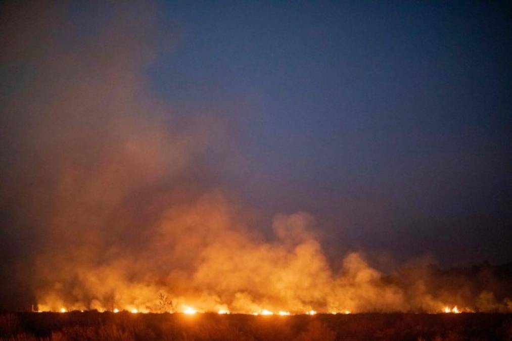 TOPSHOT - A fire burns out of control after spreading onto a farm along a highway in Nova Santa Helena municipality in northern Mato Grosso State, south in the Amazon basin in Brazil, on August 23, 2019. - Official figures show 78,383 forest fires have been recorded in Brazil this year, the highest number of any year since 2013. Experts say the clearing of land during the months-long dry season to make way for crops or grazing has aggravated the problem. More than half of the fires are in the Amazon. (Photo by Joao LAET / AFP)