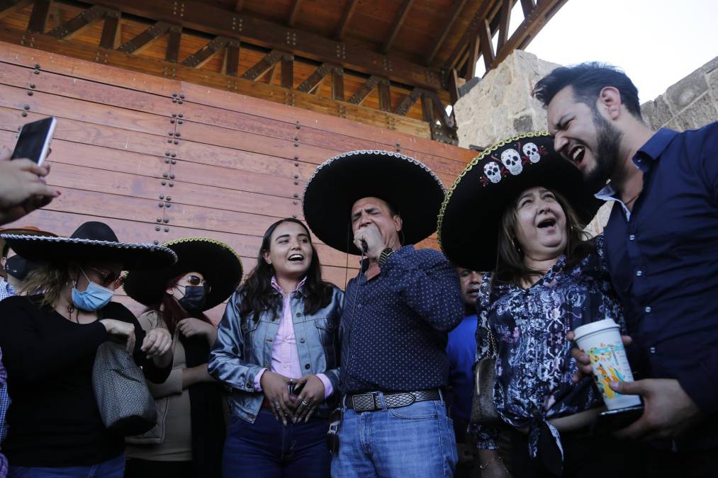 Seguidores de Chente interpretan algunos de sus éxitos musicales mientras esperan afuera del rancho Los 3 Potrillos.