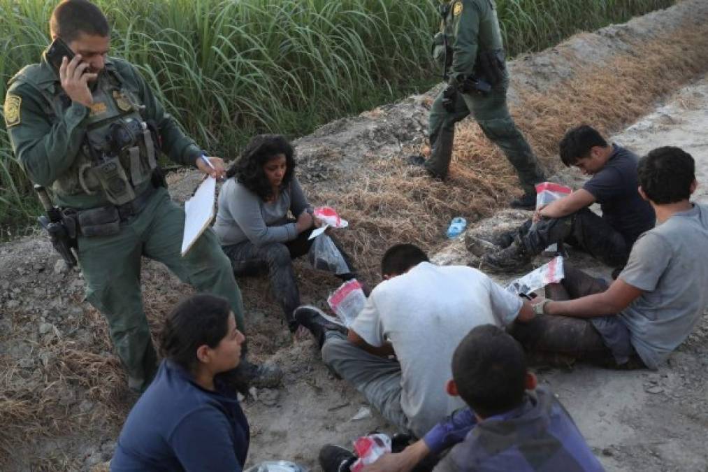 MISSION, TX - JUNE 12: U.S. Border Patrol agents watch over a group of undocumented immigrants after chasing and apprehending them in a cane field near the U.S.-Mexico Border on June 12, 2018 near Mission, Texas. U.S. Customs and Border Protection (CBP) is executing the Trump administration's 'zero tolerance' policy towards undocumented immigrants. U.S. Attorney General Jeff Sessions also said that domestic and gang violence in immigrants' country of origin would no longer qualify them for political asylum status. John Moore/Getty Images/AFP<br/><br/>== FOR NEWSPAPERS, INTERNET, TELCOS & TELEVISION USE ONLY ==<br/><br/>