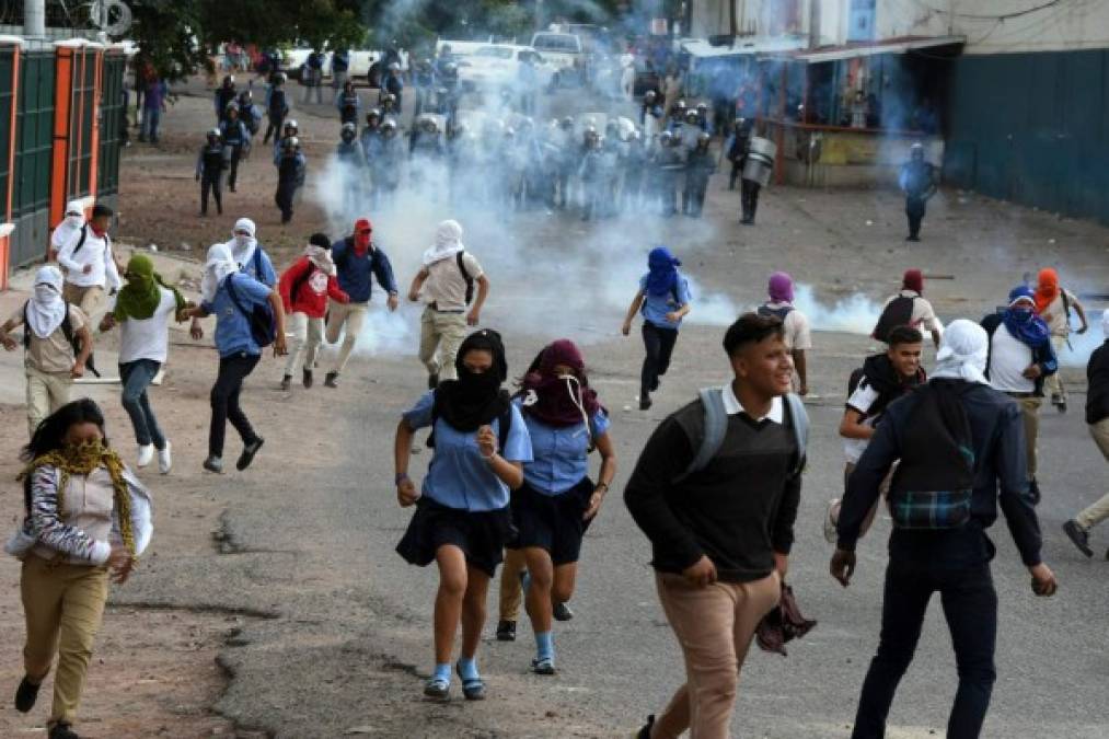 Estudiantes de los institutos Jesús Milla Selva y Técnico Honduras se enfrentaron este miércoles con agente de la Policía Antimotines. Fotos AFP