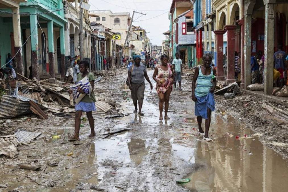 TOPSHOT - Picture taken by the UN Mission in Haiti (MINUSTAH) in the town of Jeremie, Haiti on Thursday October 6, 2016 showing people walking down a flooded street. The city lies on the western tip of Haiti and suffered the full force of the category 4 storm, leaving tens of thousands stranded. <br/>Hurricane Matthew passed over Haiti on Tuesday October 4, 2016, with heavy rains and winds. While the capital Port au Prince was mostly spared from the full strength of the class 4 hurricane, the western cities of Les Cayes and Jeremie received the full force sustaining wind and water damage across wide areas. / AFP PHOTO / UN/MINUSTAH / Logan Abassi / RESTRICTED TO EDITORIAL USE - MANDATORY CREDIT 'AFP PHOTO /LOGAN ABASSI / MINUSTAH ' - NO MARKETING - NO ADVERTISING CAMPAIGNS - DISTRIBUTED AS A SERVICE TO CLIENTS<br/><br/>