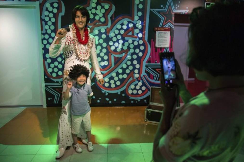 "Un niño posa para una fotografía junto a la figura de cera del cantante estadounidense Elvis Presley, en el museo de cera de Madame Tussauds, en Pekín, China."