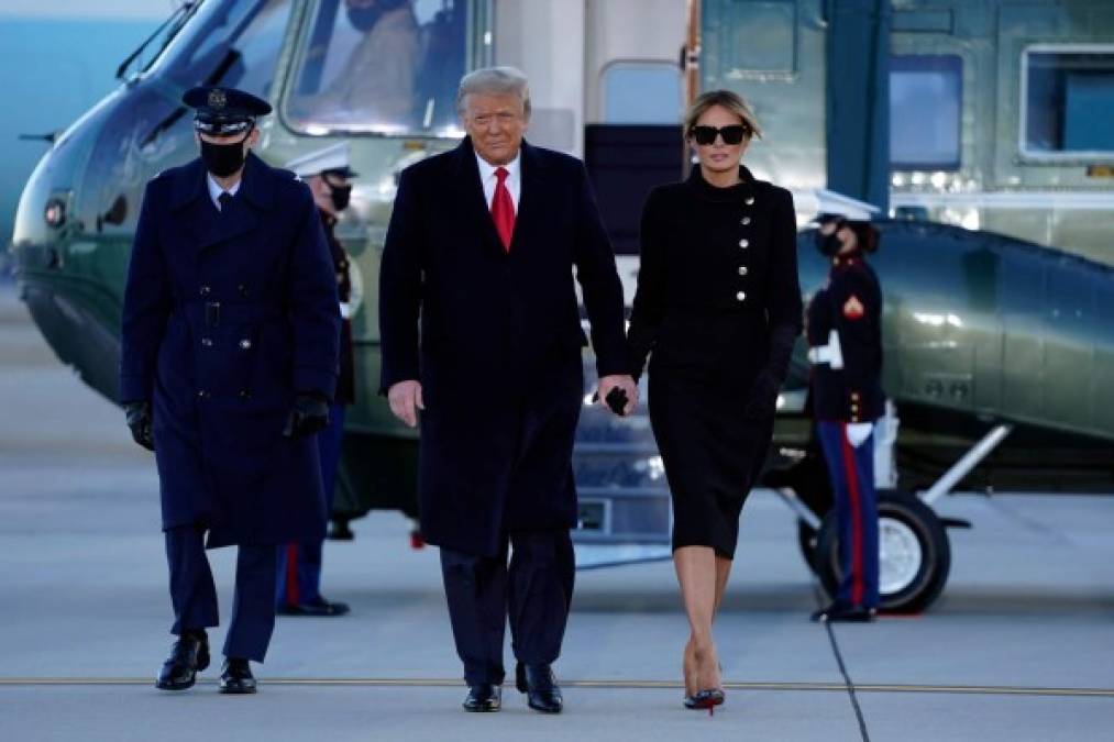 Outgoing US President Donald Trump and First Lady Melania Trump walk from Marine One at Joint Base Andrews in Maryland on January 20, 2021. - President Trump travels his Mar-a-Lago golf club residence in Palm Beach, Florida, and will not attend the inauguration for President-elect Joe Biden. (Photo by ALEX EDELMAN / AFP)
