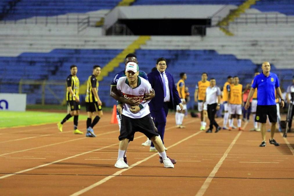 Clayvin Zúniga se arriesgó tratando de controlar a este aficionado que buscaba lanzar piedras a los aficionados del Real España.