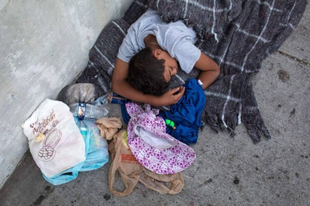 Los migrantes, muchos de ellos niños hondureños, acampan en el cruce fronterizo del lado mexicano, donde tienen que soportar las altas temperaturas y la lluvia.