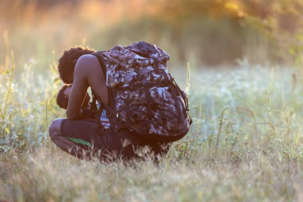 Un padre haitiano consuela a su hijo luego de regresar a territorio mexicano tras fracasar en su intento por ingresar a EEUU.