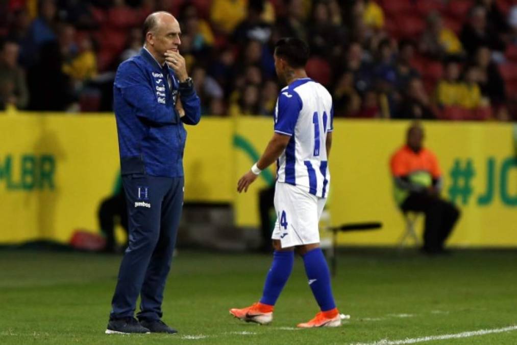 Fabián Coito, con rostro desencajado, observando el partido, mientras Michaell Chirinos se le acerca.