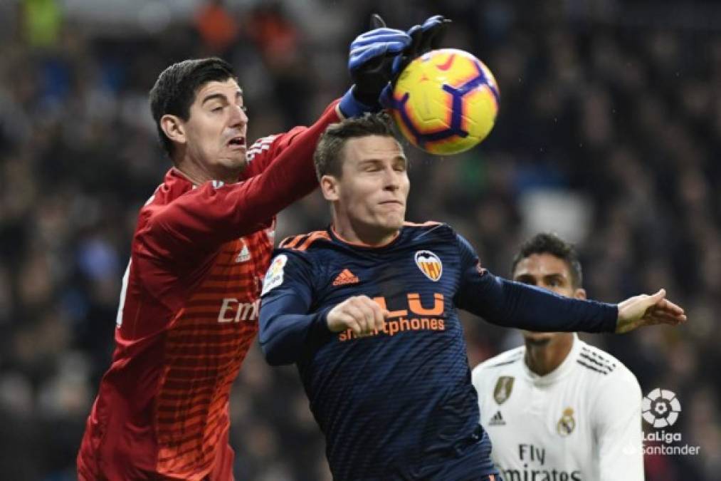 El guardameta belga del Real Madrid, Thibaut Courtois, despeja el balón con las manos ante la presión de Kevin Gameiro.