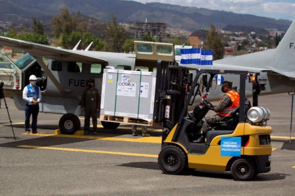 Militares hondureños ayudan a descargar las vacunas donadas bajo el mecanismo Covax, en la Base Aérea Hernán Acosta Mejía. Foto: EFE<br/>