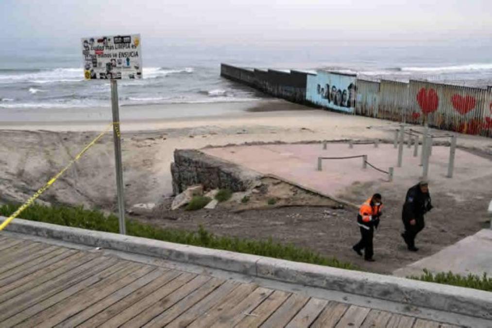 Un oficial de policía y un voluntario patrullan hoy la playa mientras permanece cerrada al público, cerca de la valla fronteriza México-Estados Unidos en Playas de Tijuana, estado de Baja California, México.