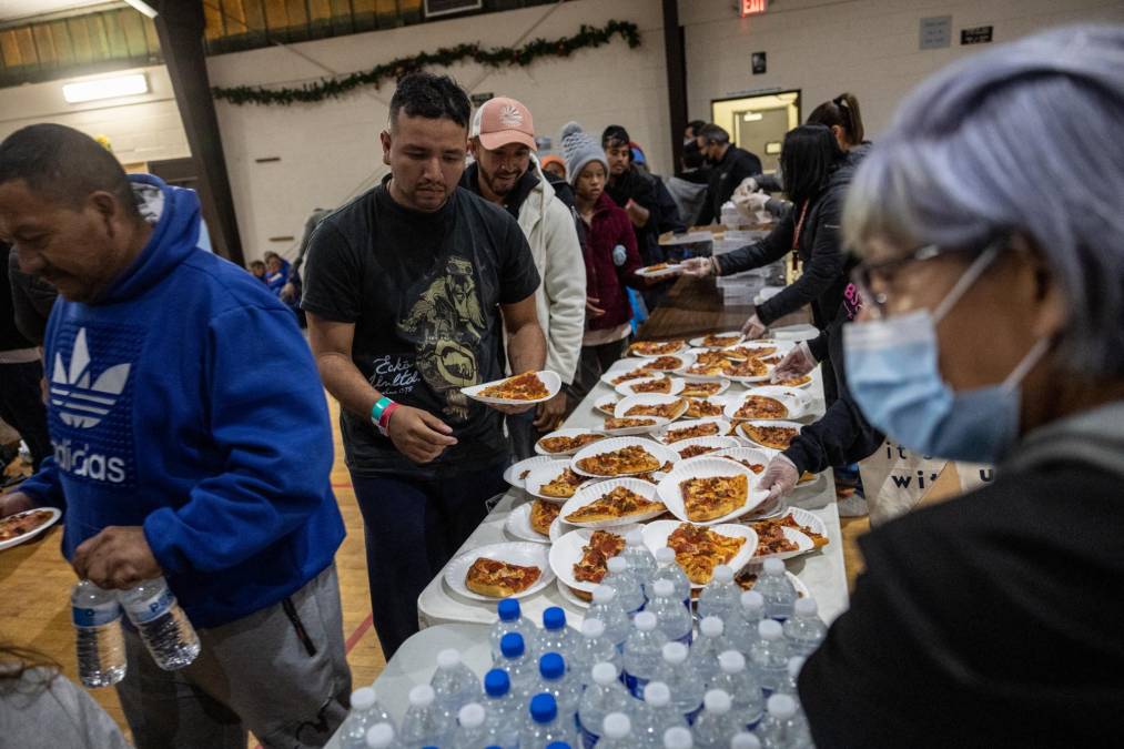 EL PASO, TEXAS - DECEMBER 17: Immigrants receive dinner at the Sacred Heart Church on December 17, 2022 in El Paso, Texas. On Saturday the city of El Paso declared a state of emergency a week after a surge of asylum seekers began crossing the border, quickly overwhelming federal immigration and city authorities. U.S. border authorities predict an even larger influx of migrants with the court-ordered end of Title 42 on December 21. John Moore/Getty Images/AFP (Photo by JOHN MOORE / GETTY IMAGES NORTH AMERICA / Getty Images via AFP)