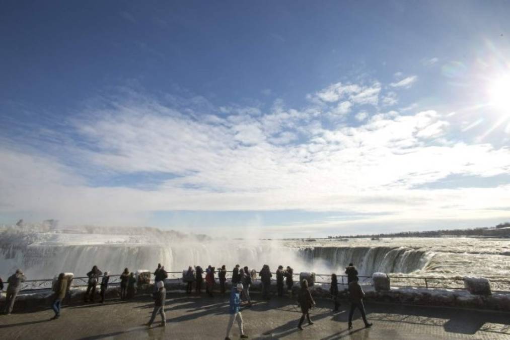Miles de turistas aprovechan para tomarse fotografías con el fondo de la cascada.
