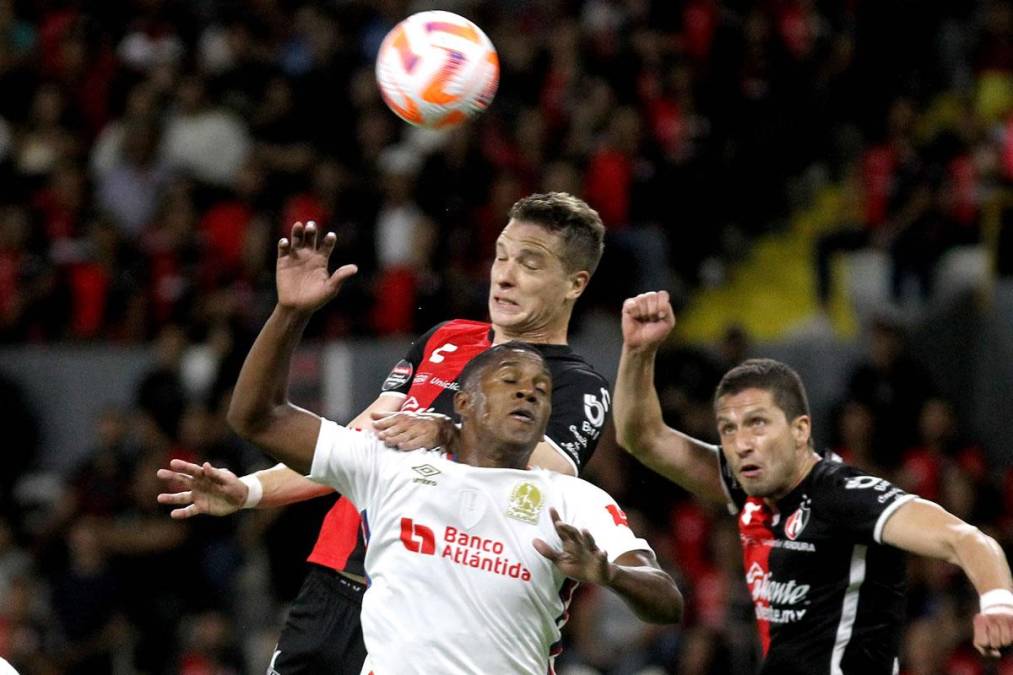 Brayan Beckeles saltando por el balón con el delantero argentino Julio Furch del Atlas.