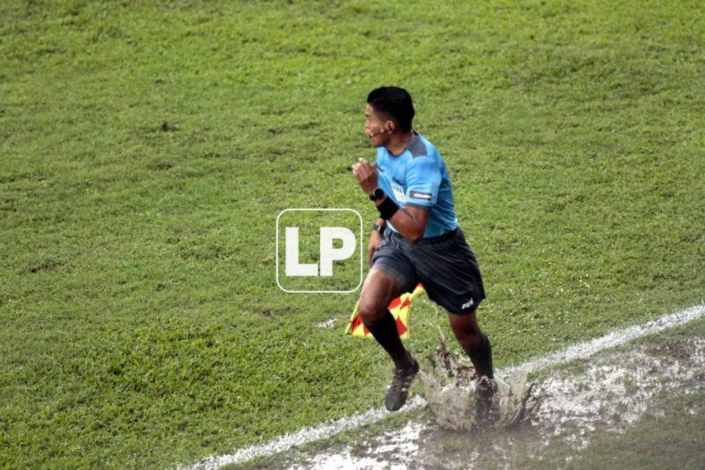 Este árbitro asistente tuvo que correr en el charco que se formó en su banda durante el partido.