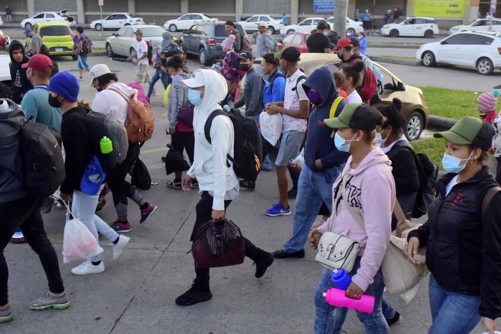 Un grupo de migrantes hondureños, acompañados de nicaragüenses, caminan durante una caravana rumbo a Estados Unidos, hoy, en la Gran Central Metropolitana de San Pedro Sula (Honduras). 