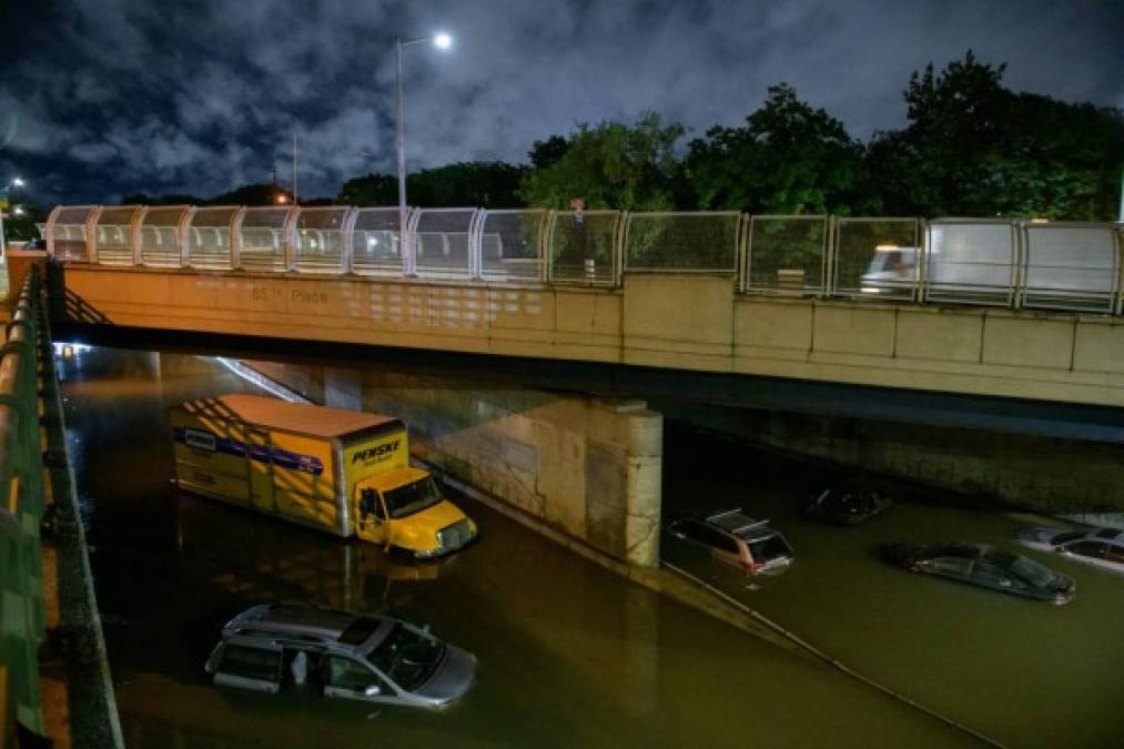 Floodwater surrounds vehicles following heavy rain on an expressway in Brooklyn, New York early on September 2, 2021, as flash flooding and record-breaking rainfall brought by the remnants of Storm Ida swept through the area. (Photo by Ed JONES / AFP)
