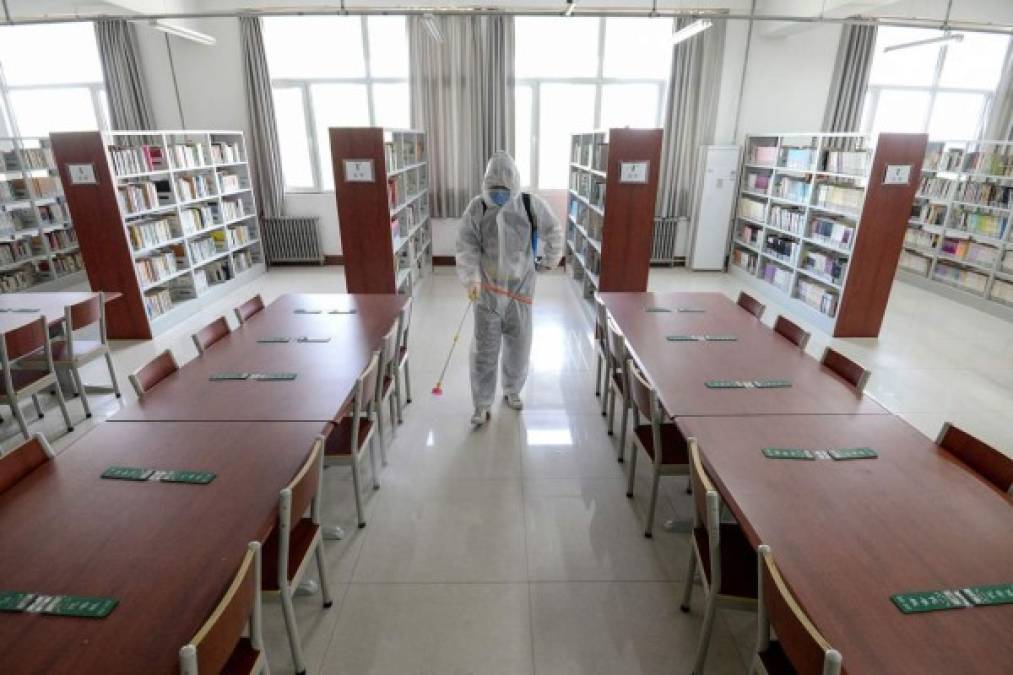 Un miembro del personal rocía desinfectante en la biblioteca de una escuela, en Handan, en la provincia de Hebei, en el norte de China.