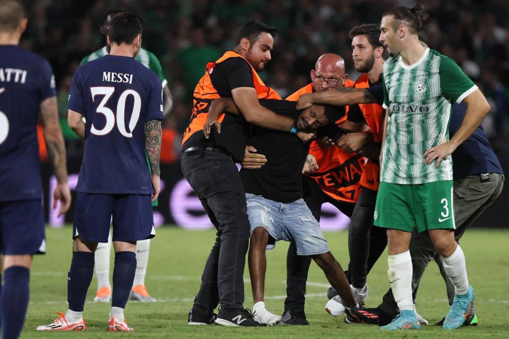 Más miembros de seguridad entraron al campo para detener al aficionado, mientras Messi observaba.