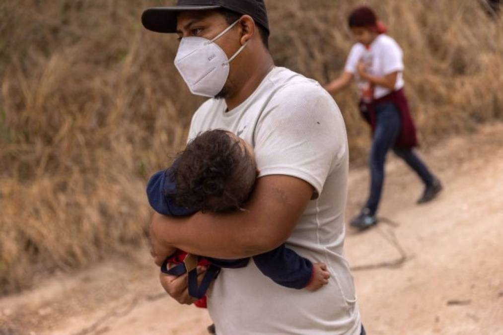 MISSION, TEXAS - MARCH 23: Asylum seekers from Honduras walk towards a U.S. Border Patrol checkpoint after crossing the Rio Grande from Mexico on March 23, 2021 near Mission, Texas. A surge of migrant families and unaccompanied minors is overwhelming border detention facilities in south Texas' Rio Grande Valley. John Moore/Getty Images/AFP<br/><br/>== FOR NEWSPAPERS, INTERNET, TELCOS & TELEVISION USE ONLY ==<br/><br/>