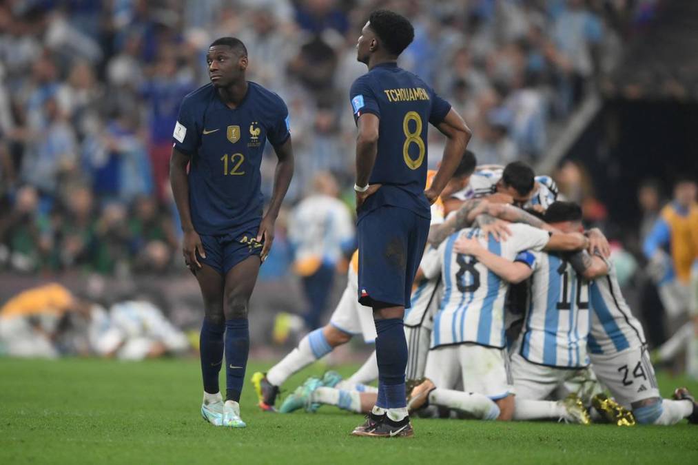 Aurélien Tchouaméni y Randal Kolo Muani se lamenta mientras al fondo celebran los argentinos por quedar campeones del Mundial de Qatar 2022.