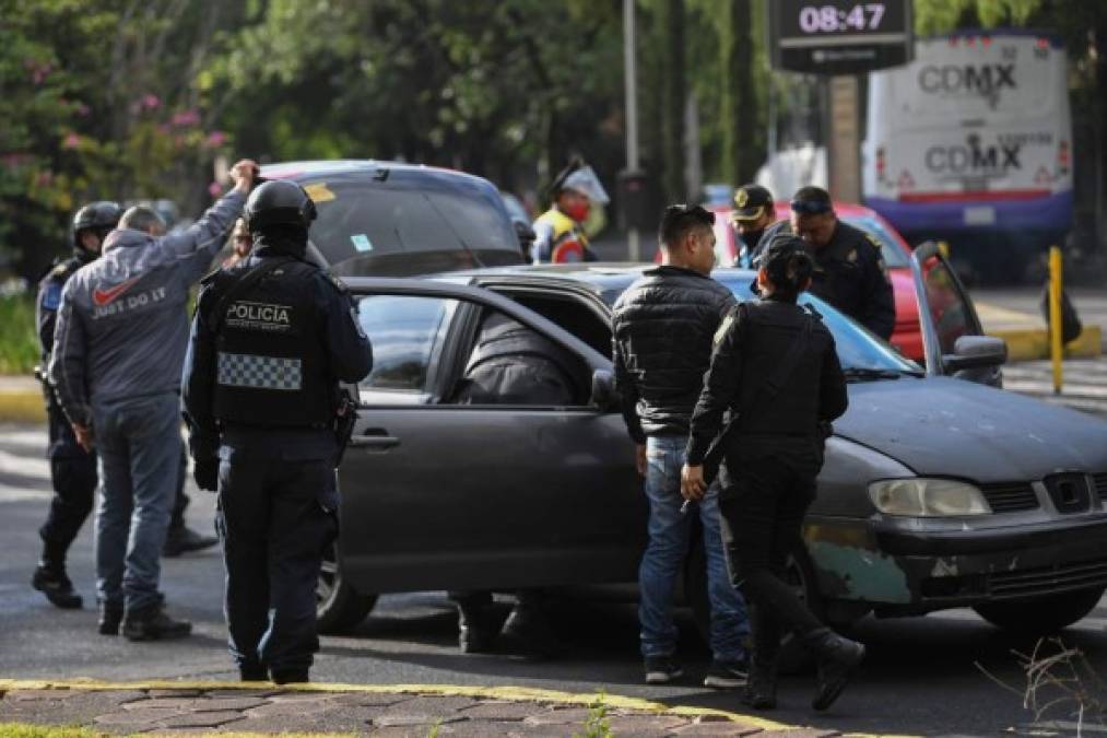 Police officers inspect a car after Mexico City's Public Security Secretary Omar Garcia Harfuch was wounded in an attack in Mexico City, on June 26, 2020. (Photo by PEDRO PARDO / AFP)