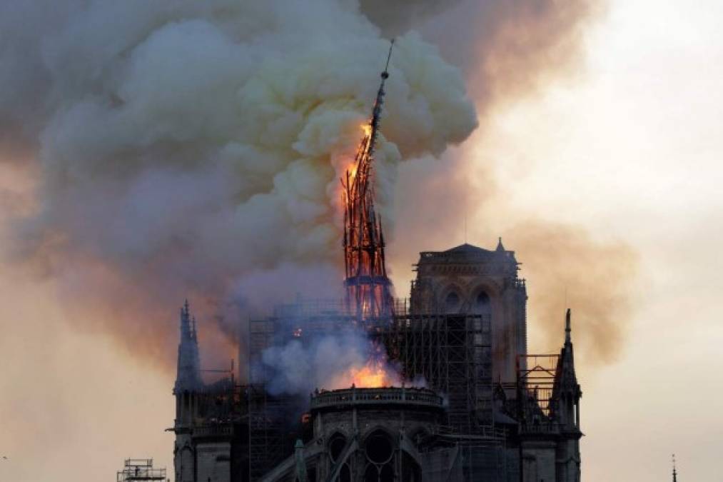 El campanario de la histórica catedral de Notre-Dame se derrumba cuando la catedral se ve envuelta en llamas.