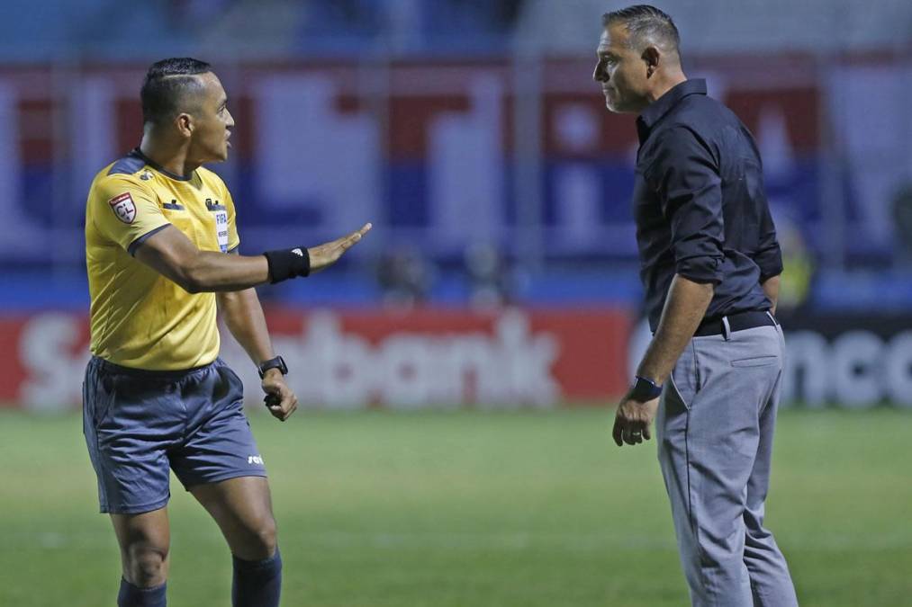 El árbitro salvadoreño Iván Bartón le pide calma al entrenador motagüense Hernán ‘La Tota‘ Medina.