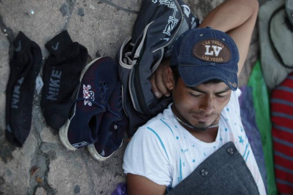 Entre las largas caminatas, los migrantes se reúnen en cualquier sombra para tomar un descanso y luego proseguir su trayecto.