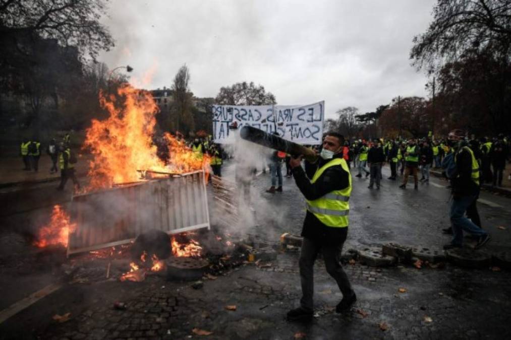Protesters build a barricade during a protest of Yellow vests (Gilets jaunes) against rising oil prices and living costs, on December 1, 2018 in Paris. (Photo by Abdulmonam EASSA / AFP)