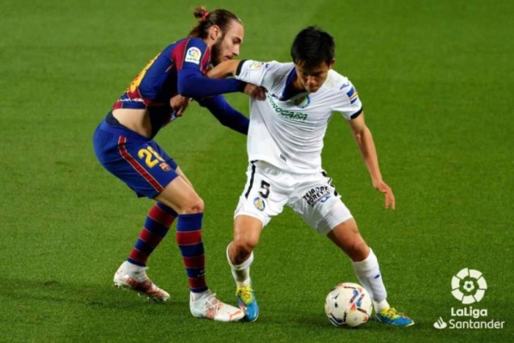 Óscar Mingueza y Takefusa Kubo se sujetan de las camisetas luchando por el balón.