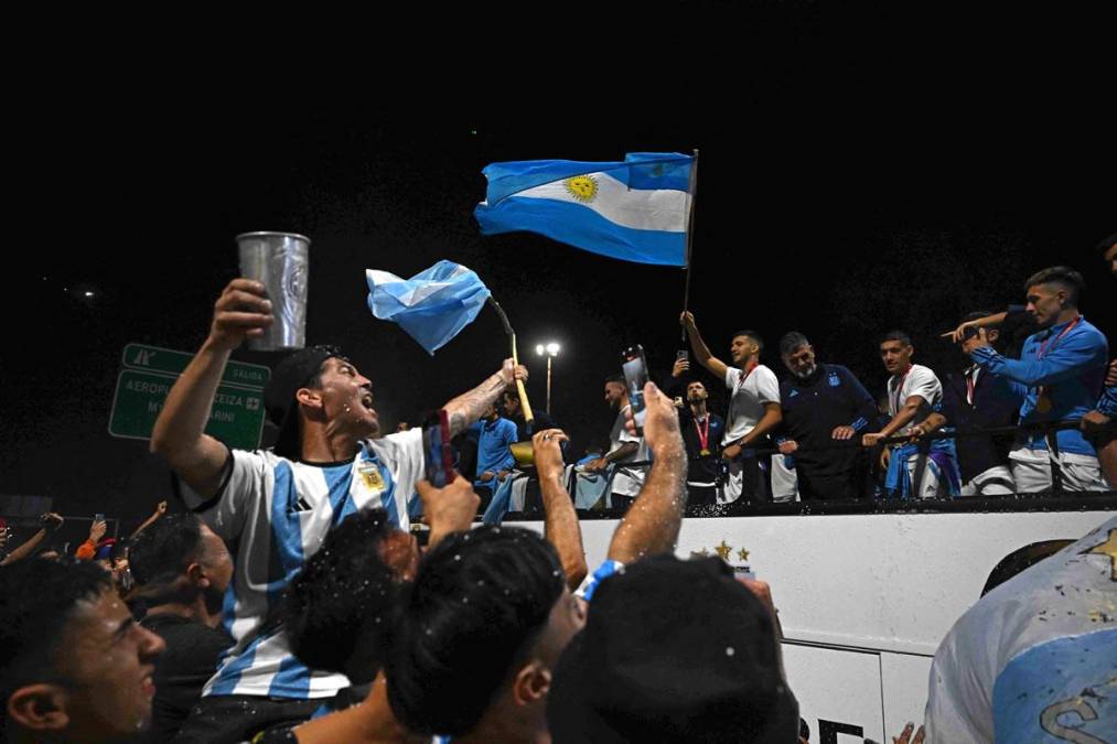 Con teléfonos móviles que iluminaban la negra noche, los aficionados seguían el recorrido del autobús con banderas argentinas, bengalas y fuegos de artificio y lanzando cartas y balones a los futbolistas.