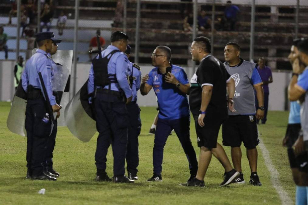 Miembros del Platense charlan con elementos de la Policía Nacional luego de que el partido se detuviera por minutos.