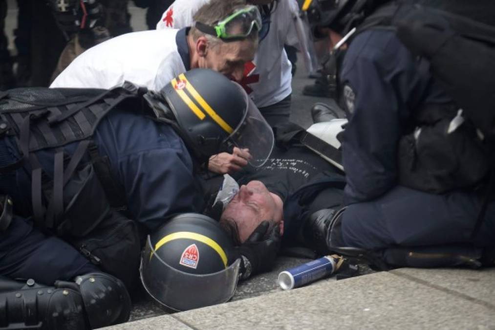 Un policía herido durante los disturbios es atendido por sus compañeros.