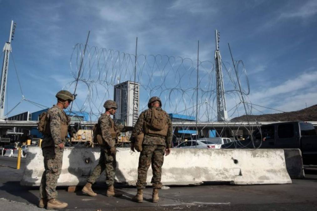 US Department of Defence personnel installs barriers requested by Custom and Border Protection at the San Ysidro port of entry, San Diego, US, under the Operation Secure Line anticipating the arrival of Central American migrants heading towards the border, as seen from the Mexican side of the border in Tijuana, Mexico, on November 13, 2018. - US Defence Secretary Jim Mattis said Tuesday he will visit the US-Mexico border, where thousands of active-duty soldiers have been deployed to help border police prepare for the arrival of a 'caravan' of migrants. (Photo by GUILLERMO ARIAS / AFP)