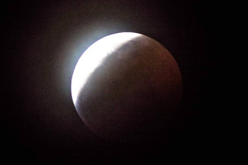 La sombra de la Tierra comienza a oscurecer totalmente la vista de la llamada Superluna de sangre en en Miami, Florida. AFP
